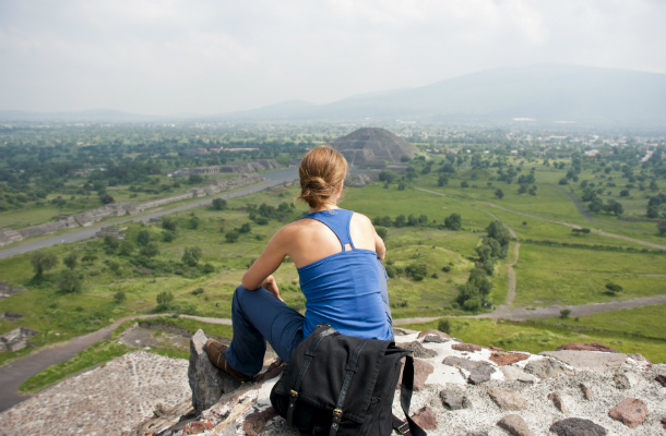 A backpacker looking over Mayan ruins.